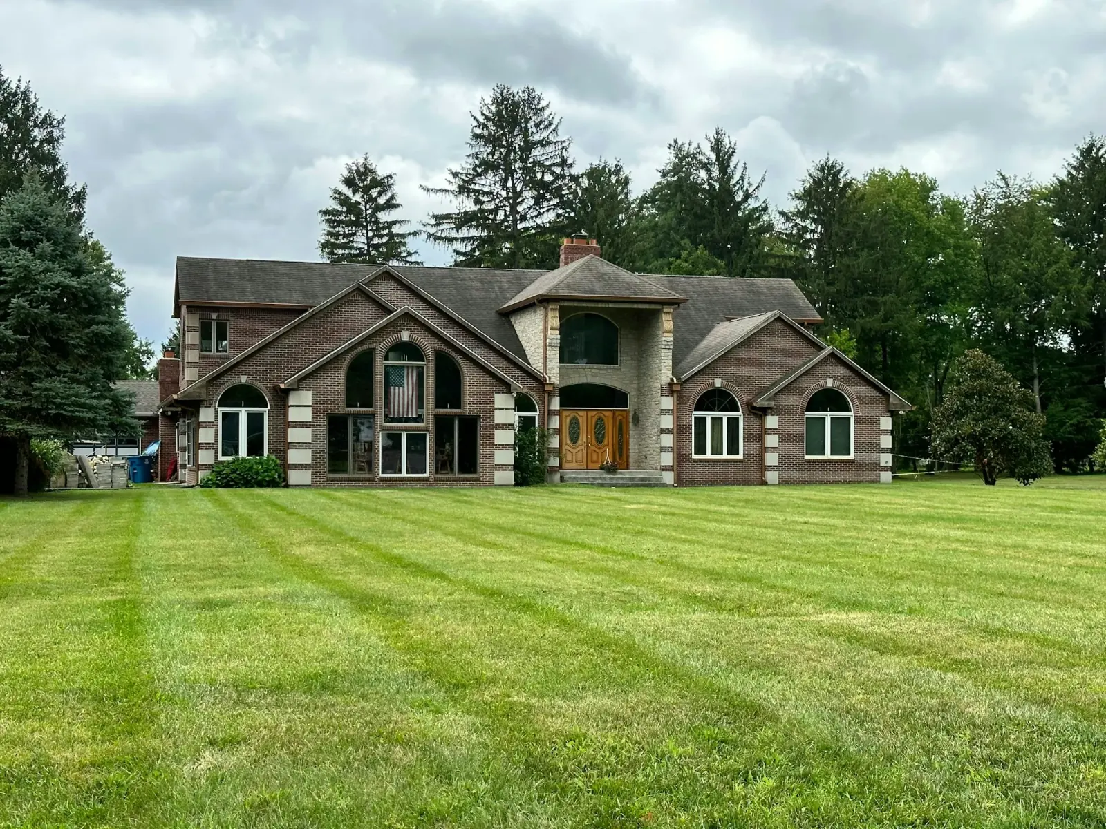 A green residential lawn bordered by mature trees